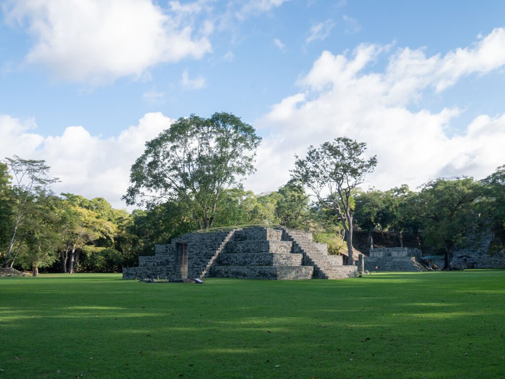 Stone structures and temples in the central plaza of the Copán UNESCO archaeological site, featured on a Copán day tour from Guatemala City by air for travelers who fly from Guatemala to Copán.