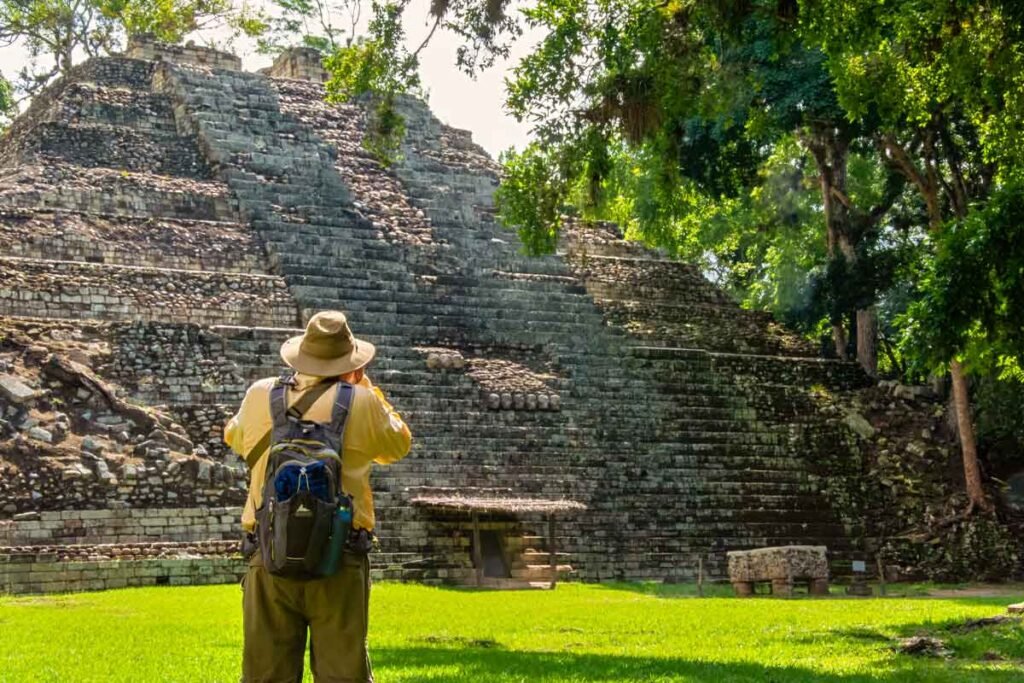 Traveler photographing the pyramid at the Copán UNESCO archaeological site during a Copán day tour from Guatemala City by air — a cultural journey for those who fly from Guatemala to Copán.