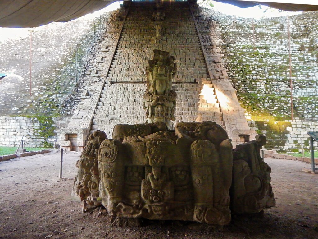 Altar and carved stela in front of the Hieroglyphic Stairway at the Copán UNESCO archaeological site, captured during a Copán day tour from Guatemala City by air — ideal for travelers who fly from Guatemala to Copán to explore ancient Maya history.